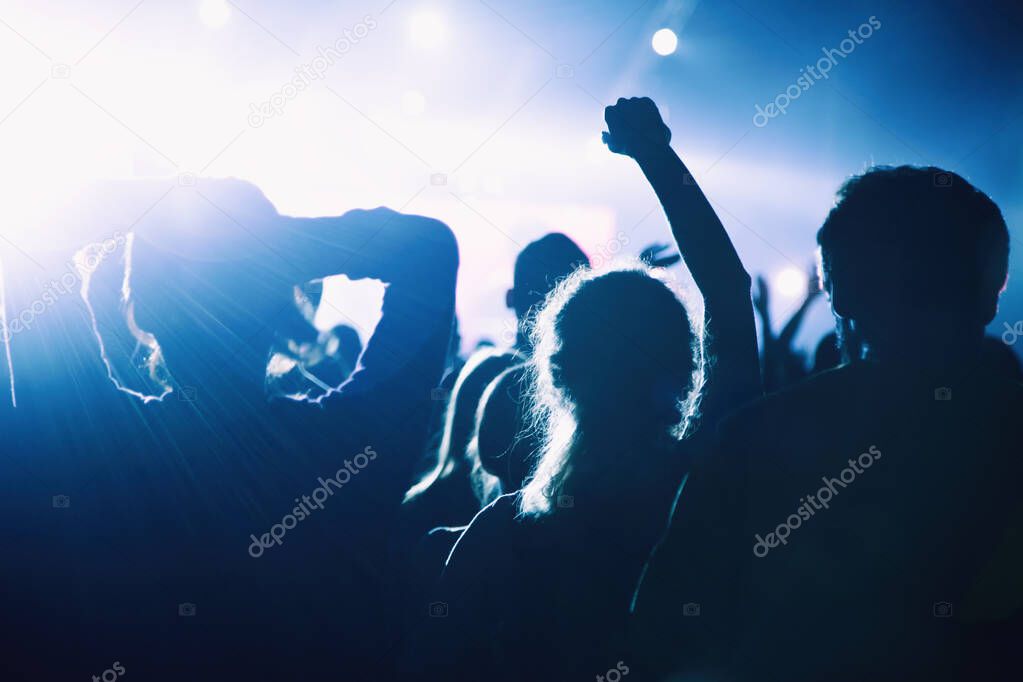 Silhouette of a crowd of fans at a concert.