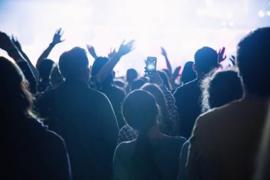 Bir konserdeki hayran kalabalığının silueti..