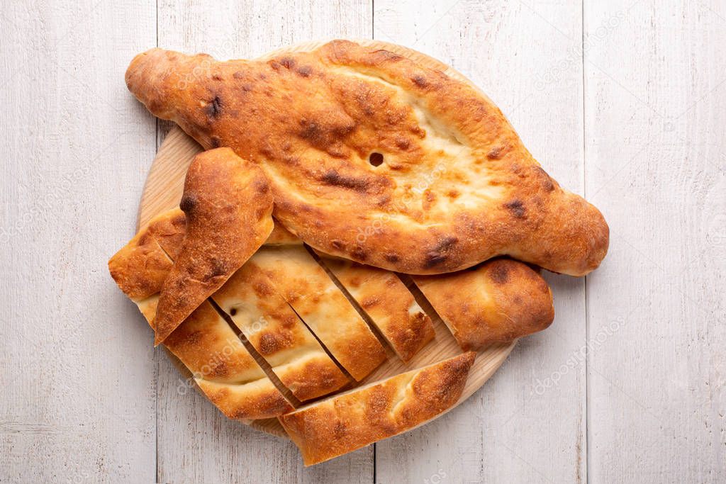 Traditional national Georgian Shoti bread on a white wooden background.