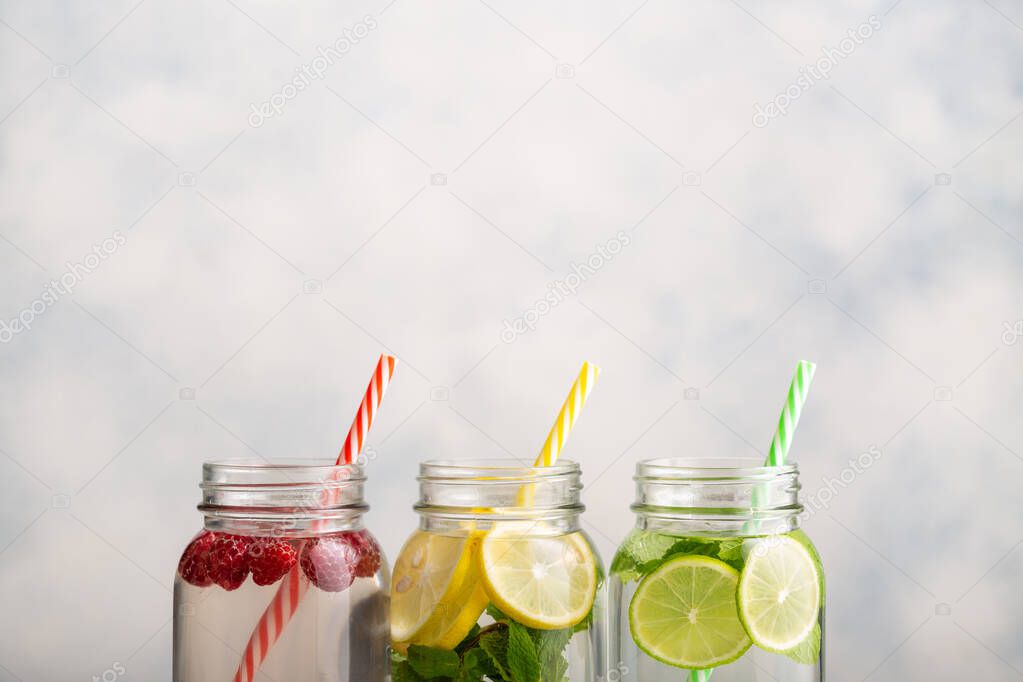 Detox water in jars with raspberries, lemon, lime and mint.