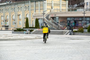 Kyiv, Ukrayna - 22 Mart 2020: Kiev 'deki boş bir posta meydanında Glovo dağıtım servisi kuryesi. Şehirde insanların olmadığı popüler bir yer. COVID-19 sırasında karantina.