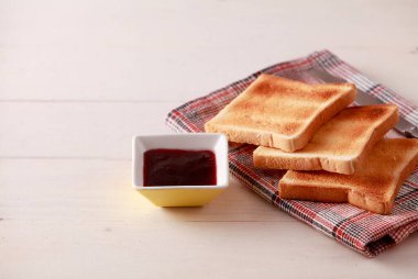 Beyaz ahşap arka planda dilimlenmiş ekmek tostları.