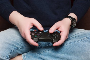 Beyaz adam elinde joystick ile evde video oyunu oynuyor. Ev konseptinde kalıyor.