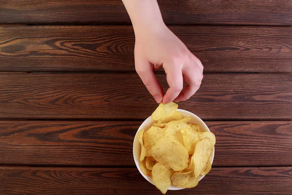 Hand Hält Kartoffelchips Auf Schale Isoliert Auf Holz Hintergrund — Stockfoto