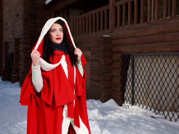 Brunette Meisje Een Rode Mantel Winter Met Houten Gebouw Achtergrond — Stockfoto