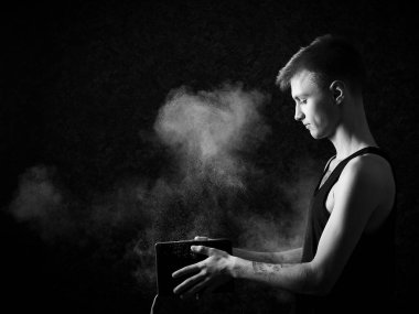 Genç yakışıklı adam kitabı tozla kapatıyor.