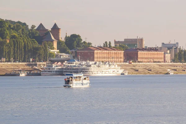 Un pequeño barco de recreo camina a lo largo del río al fondo de Nizhny Novgorod — Foto de Stock