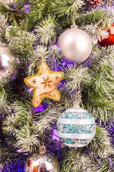 Achtergrond met de takken van een kerstboom die versierd met speelgoed — Stockfoto