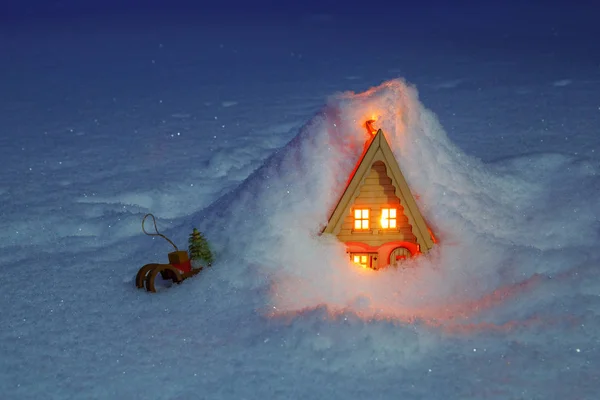 Kızak bir rüzgârla oluşan kar yığını altında olan oyuncak ev — Stok fotoğraf