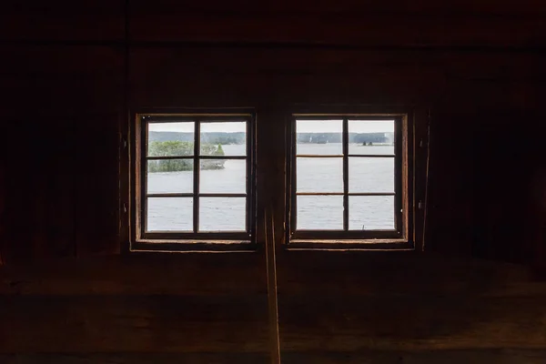 Zwei Fenster in einer dunklen Holzkirche — Stockfoto