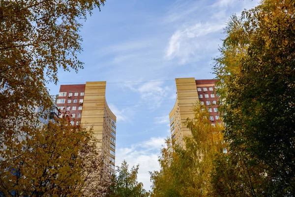 Zwei Türme eines Mehrfamilienhauses hinter Bäumen — Stockfoto
