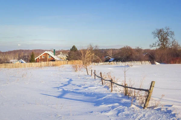 Wiejskie domy i ogrodzenie w zimowy słoneczny dzień — Zdjęcie stockowe