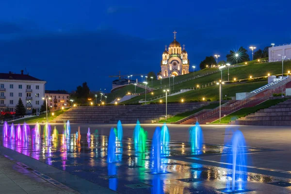 Flerfärgade jetstrålar av fontänen och St George Church i Sama — Stockfoto