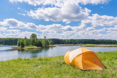 Yazın göl kenarında bir turist çadırında dinlen.