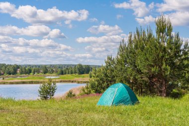 Ormanın ve gölün kıyısında turist çadırı.