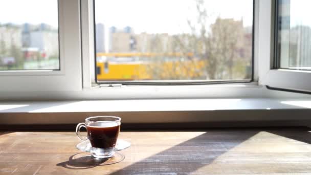 šálek horké aroma kávy stojí vedle otevřeného okna