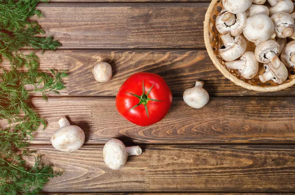 Champinjoner och tomater på ett träbord — Stockfoto