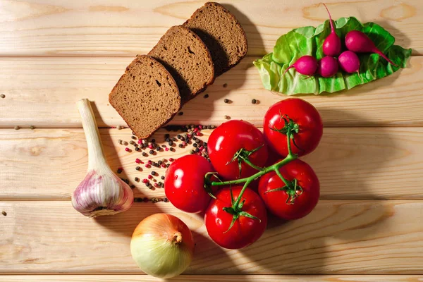 Bröd, rädisor, tomater, lök, vitlök ört och kryddor på trä — Stockfoto