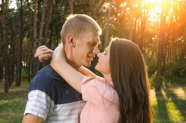 Seven çift birbirlerine açık havada günbatımında sarılma