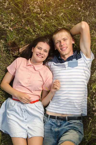 Закохана пара лежить на зеленій траві — стокове фото