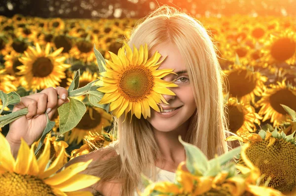 çiçeklenme üzerinde genç güzel kadın ayçiçeği alan