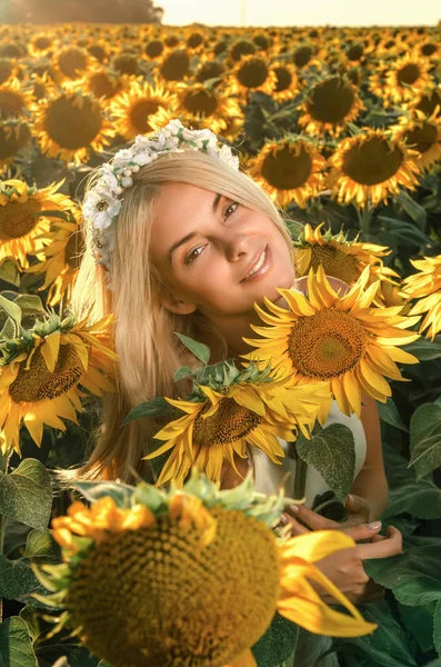 çiçeklenme üzerinde genç güzel kadın ayçiçeği alan