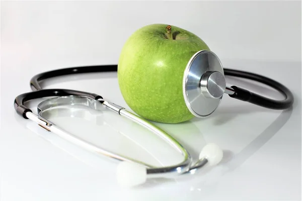 Una imagen conceptual de una manzana y un estetoscopio —  Fotos de Stock