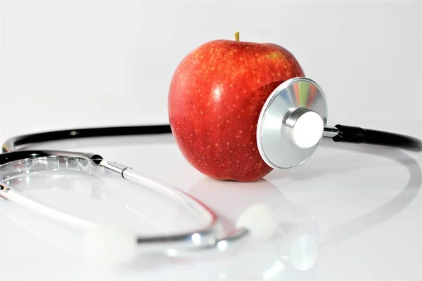 Una imagen conceptual de una manzana y un estetoscopio —  Fotos de Stock