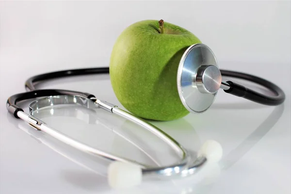 Una imagen conceptual de una manzana y un estetoscopio —  Fotos de Stock