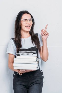 kitap tutan ve parmak ile işaret genç beyaz öğrenci