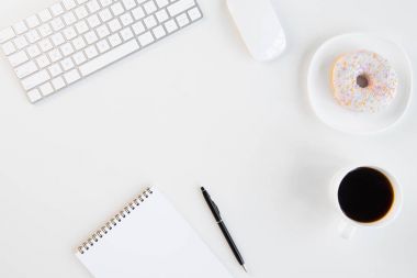 Halka üstten görünüm fincan kahve, boş defter kalem ile işyerinde klavye ve bilgisayar fare ile
