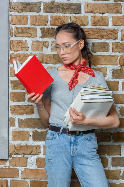 Νέοι συλλογισμένος Ασιάτισσα φοιτήτρια σε γυαλιά ανάγνωσης βιβλίων — Φωτογραφία Αρχείου