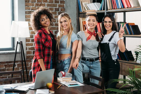 Young stylish multiethnic women posing together at home library — Stock Photo, Image