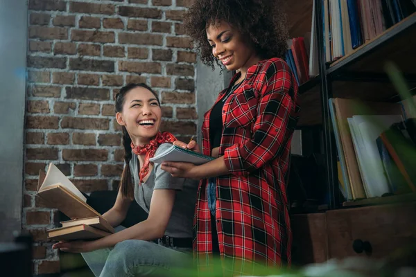 Atractivas mujeres jóvenes estudiando junto con libros y sonriendo —  Fotos de Stock