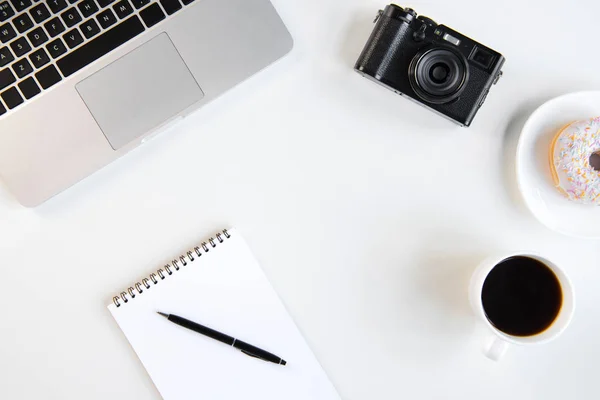 Pohled shora na laptop, prázdný zápisník s perem, šálek kávy a kamery na pracovišti — Stock fotografie