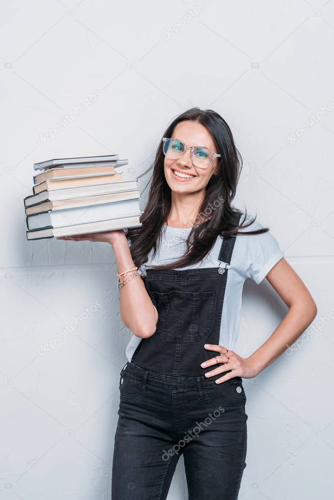 smiling caucasian girl holding books and looking at camera