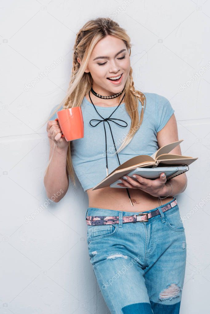 caucasian blonde girl drinking coffee and reading books with facial expression