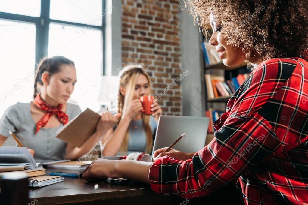 young multiethnic women working while sitting at table in home office