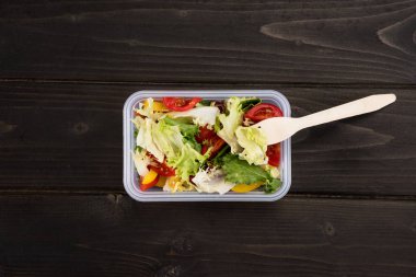 Plastik kutu sağlıklı salata üstten görünüm ahşap tablo