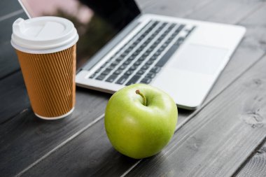 Olgun elma kahve ve ahşap masa üstünde laptop ile yakın çekim
