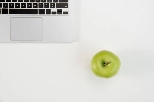 Widok z góry otwarty laptop i świeże zielone jabłko na białym tle na szarym tle — Zdjęcie stockowe