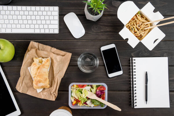 top view of digital devices with food with glass of water mock-up on tabletop