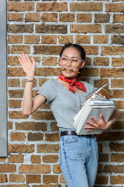 Jovem asiático mulher segurando livros com mão gesto — Fotografia de Stock