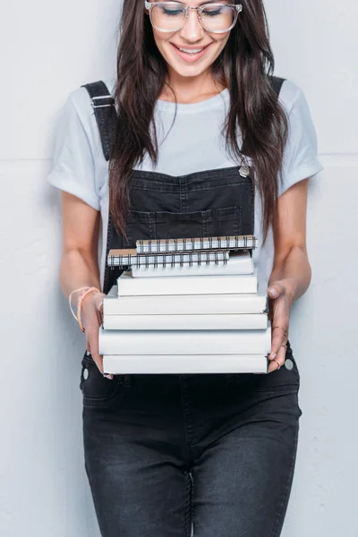 Junge lächelnde Kaukasierin mit Brille und Büchern — Stockfoto