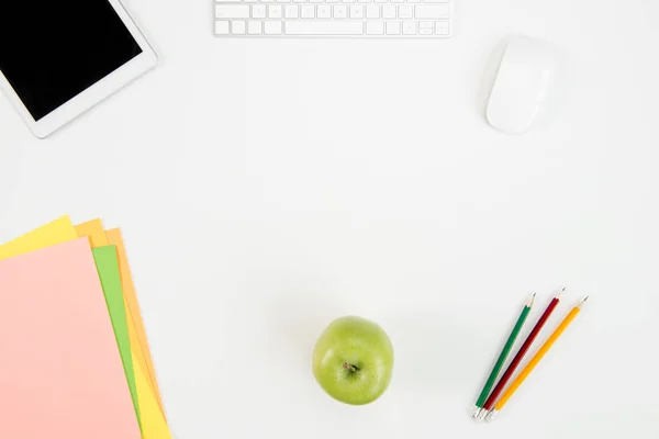 Vista dall'alto di tastiera, mouse del computer, tablet digitale con schermo vuoto, mela verde e forniture per ufficio sul posto di lavoro — Foto stock