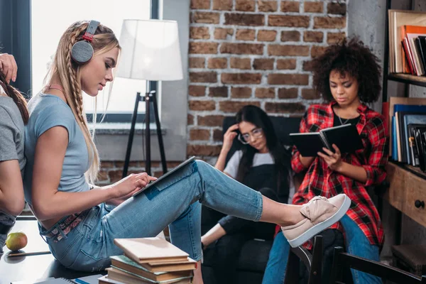 Grupo multiétnico de estudiantes que estudian junto con libros y tabletas digitales - foto de stock