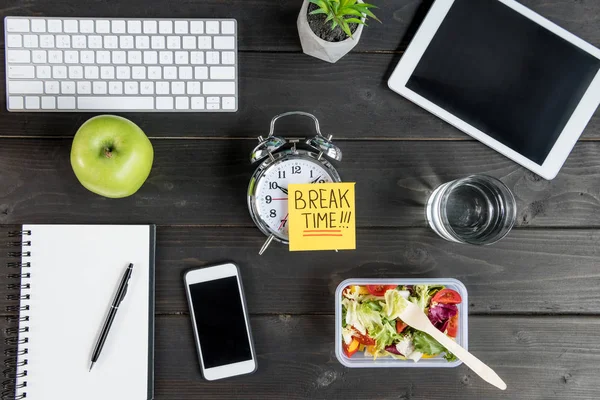 Vista superior de los dispositivos digitales con manzana y ensalada con despertador maqueta en la mesa — Stock Photo