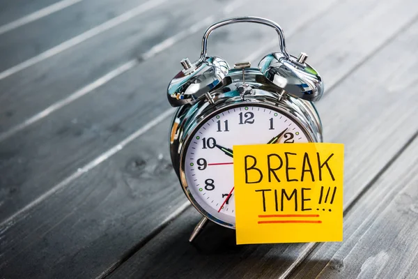 Close up of alarm clock with message break time on wooden tabletop — Stock Photo