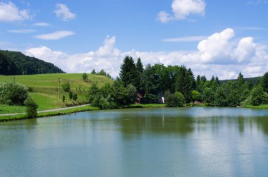 Yeşil çayırlar tarafından çevrili gölet