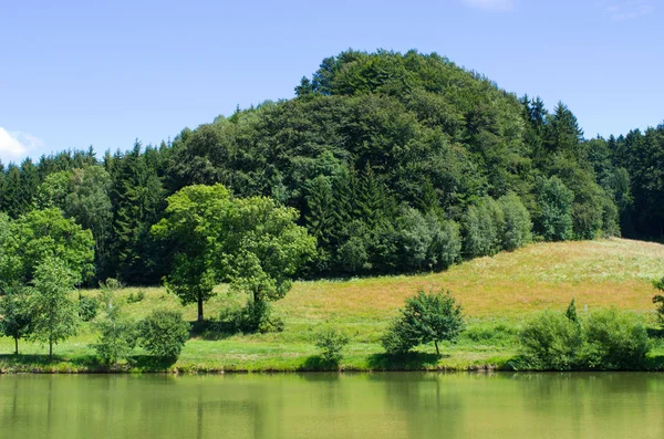 Teich umgeben von grünen Wiesen — Stockfoto